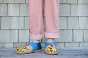 a person standing on a wooden floor wearing slippers