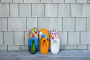 a row of colorful slippers sitting on top of a wooden floor