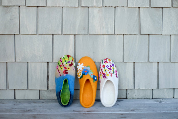 a row of colorful slippers sitting on top of a wooden floor