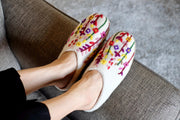 a woman&#39;s feet in slippers on a couch